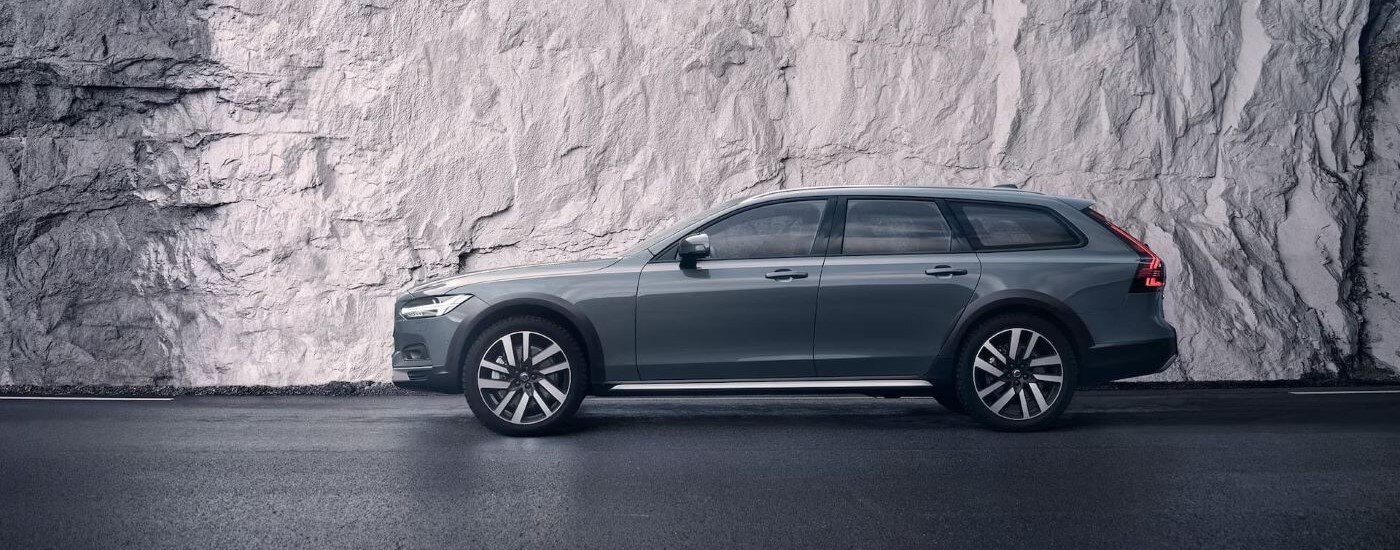 2023 Volvo V90 Cross Country - Side.jpg A silver 2023 Volvo V90 Cross Country is shown from the side in front of a rock wall.