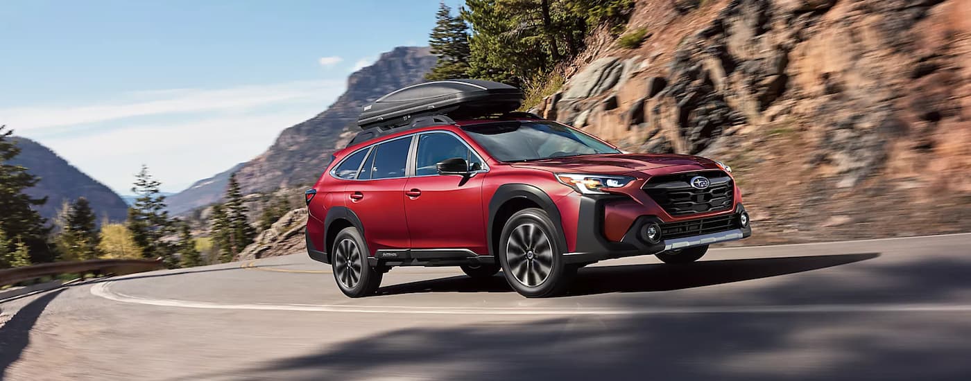 SUVs%20for%20Sale%20in%20Raleigh%202023%20Subaru%20Outback%20-%20Red%20-%20Rocks.jpg Red 2023 Subaru Outback driving on a winding road.