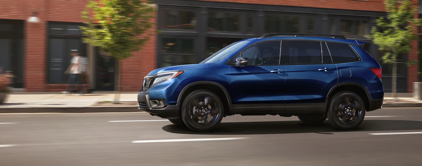 Used Car Dealership - 2020 Honda Passport Elite - Side.jpg A blue 2020 Honda Passport Elite is shown from the side after leaving a used car dealership.
