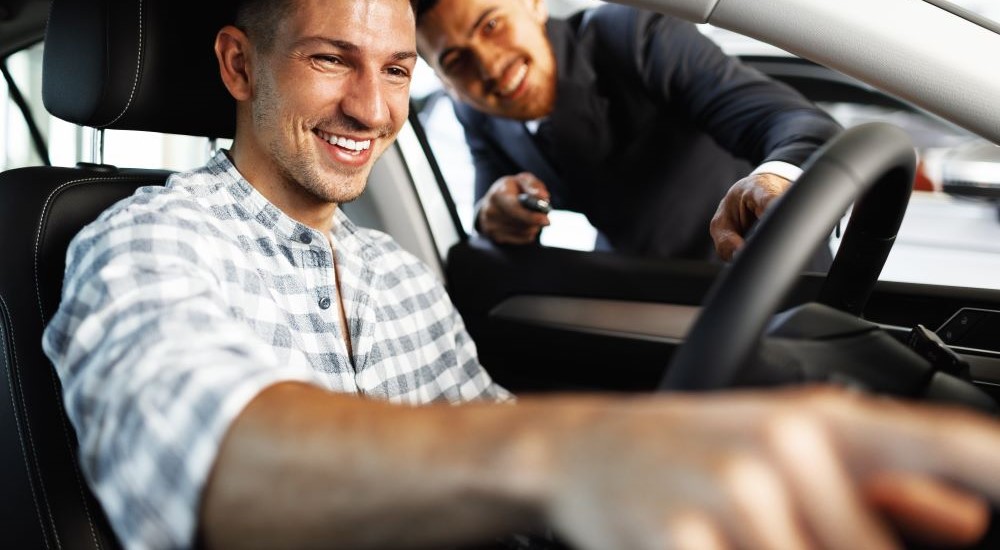 Car Dealership - Smile.jpg A salesperson and customer are shown smiling at a car dealership.