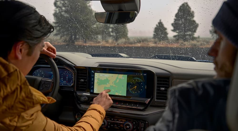 Two people using the infotainment screen in a 2025 Chevy Silverado 1500
