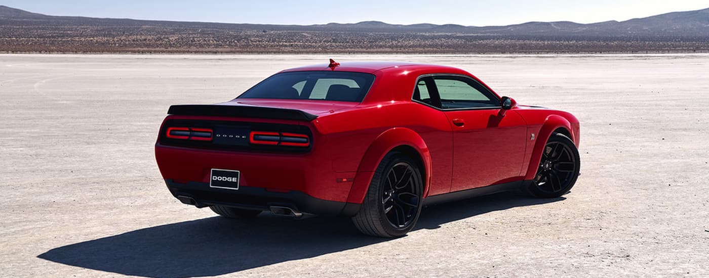 Car%20Dealership%20Near%20Cary%20-%202021%20Dodge%20Challenger%20-%20Red.jpg Red 2021 Dodge Challenger parked in an open dirt lot.