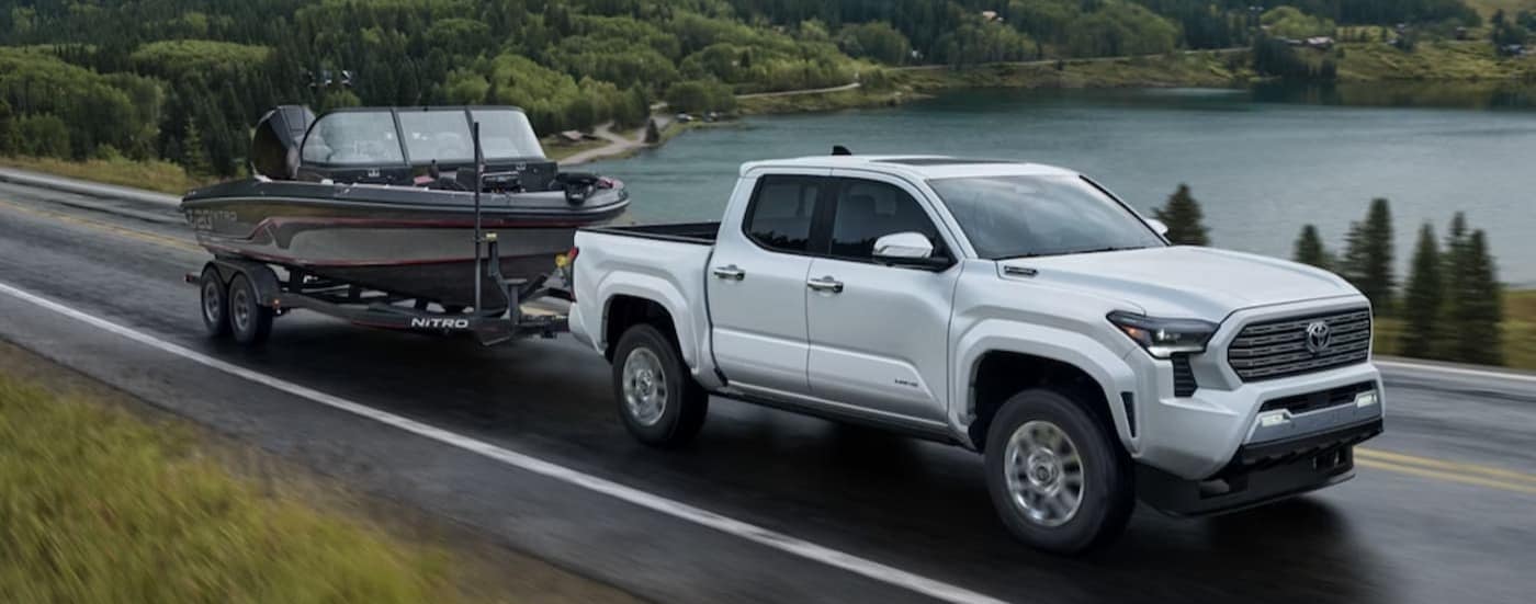 truck%20for%20sale%20near%20Cary%20-%202025%20Toyota%20Tacoma%20Limited%20-%20Boat.jpg A white 2025 Toyota Tacoma Limited towing a boat after viewing a truck for sale near Cary.