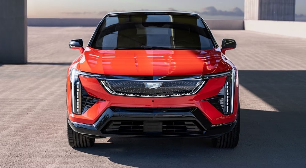 A red 2025 Cadillac OPTIQ is shown from the front on concrete.