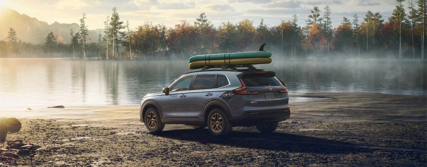 SUVs%20for%20Sale%20in%20Raleigh%202025%20Honda%20CR-V%20Hybrid%20EX%20-%20Grey%20Lake.jpg Grey 2025 Honda CR-V Hybrid parked near a lake.