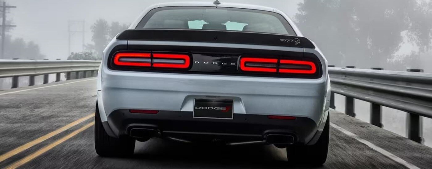 2023 Dodge Challenger SRT - Fog.jpg A silver 2023 Dodge Challenger SRT is shown from the rear driving through fog.