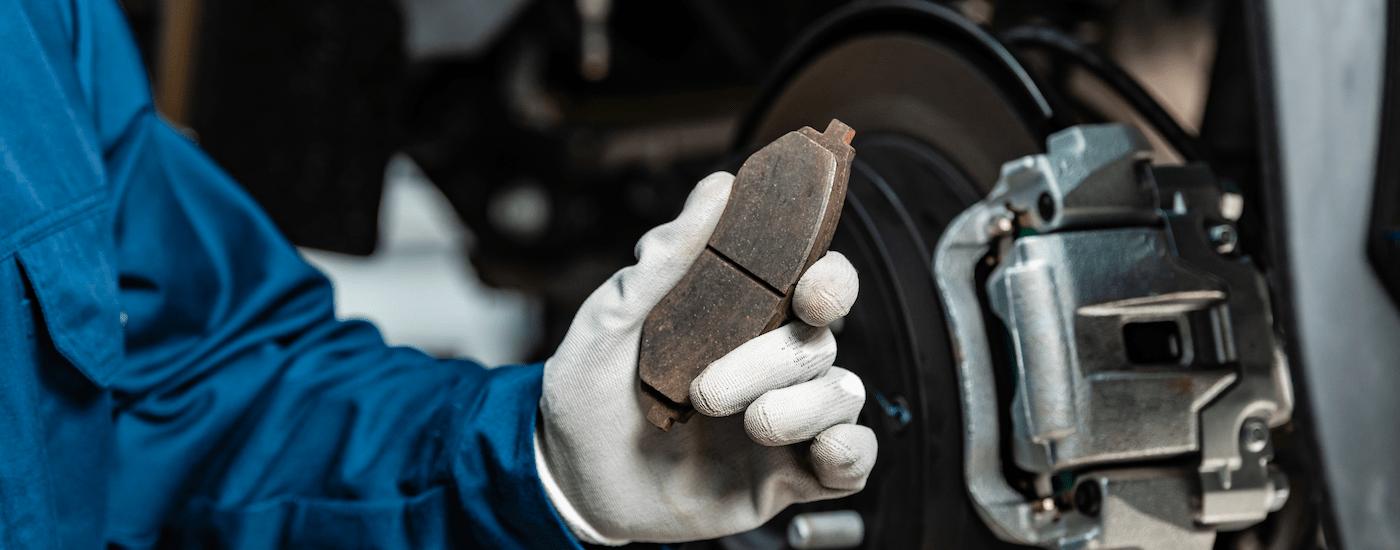 Brake%20Service%20in%20Charlotte%20-%20Brake%20Pad.jpg A mechanic is holding a brake pad for a vehicle.