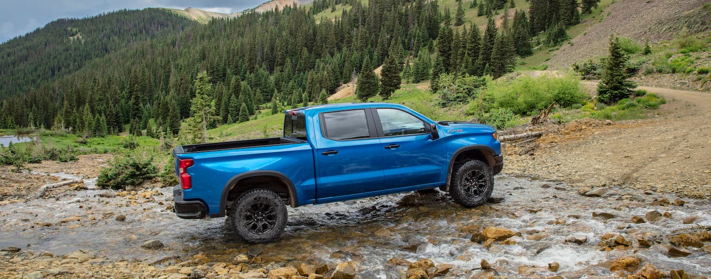 A blue 2025 Chevy Silverado 1500 ZR2 from the side while off-road.
