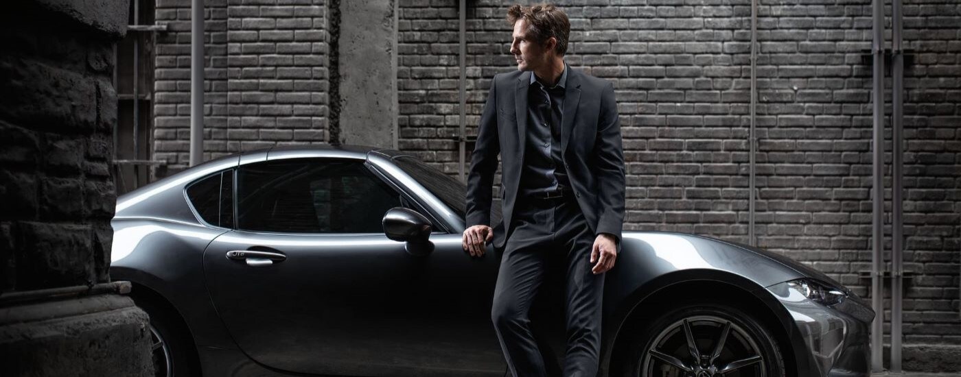 2022 Mazda MX-5 Miata RF - Lean.jpg A person is shown leaning against a silver 2022 Mazda MX-5 Miata RF.